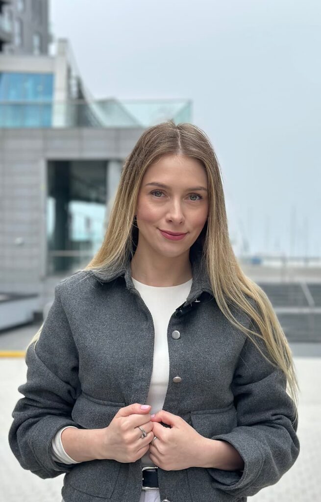 Paulina Stępniewska w szarym płaszczu na zewnątrz. Paulina jest niezależną ekspertką kredytową gotową do pomocy swoim klientom.