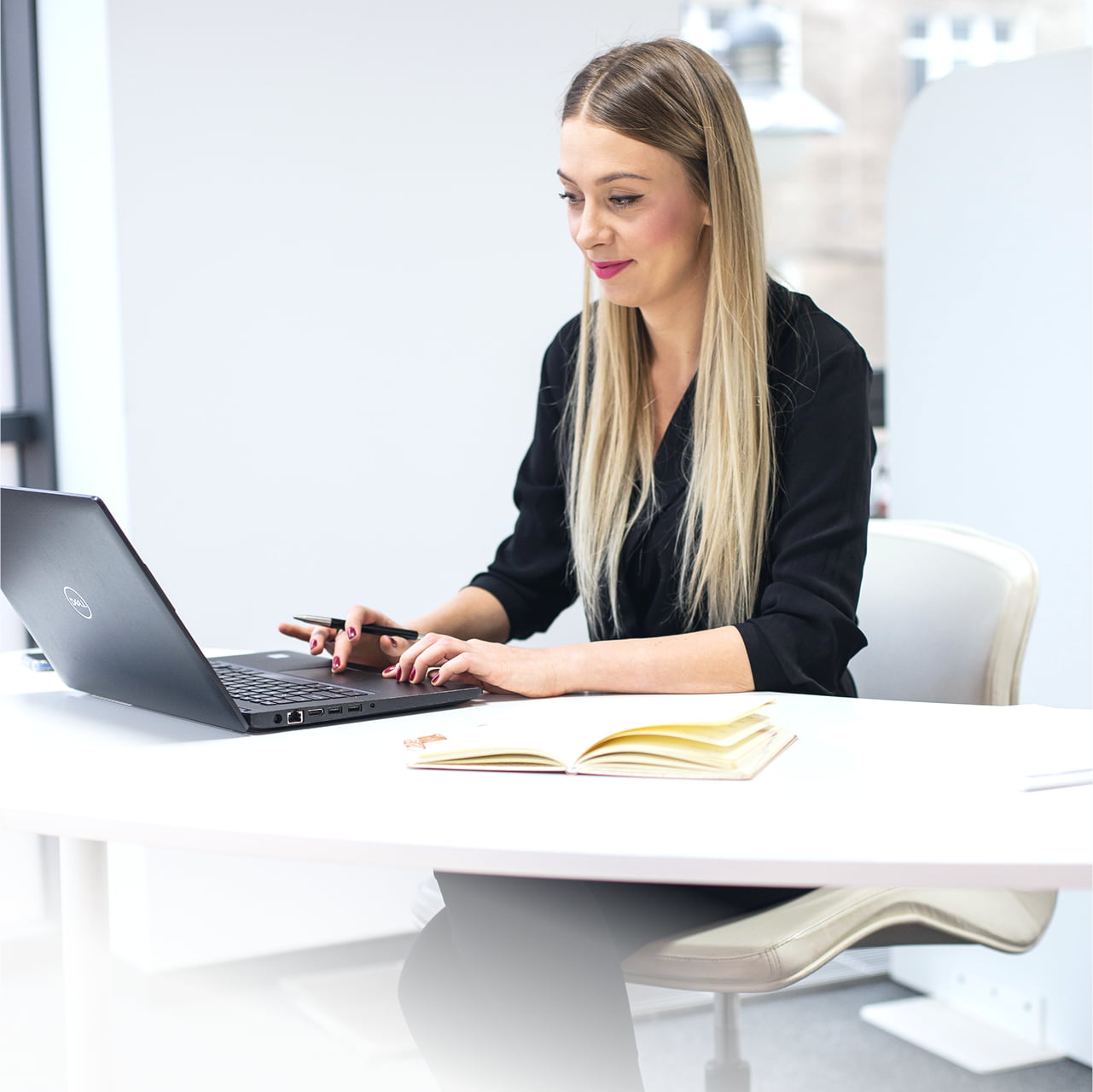 Kobieta pracująca na laptopie przy biurku.